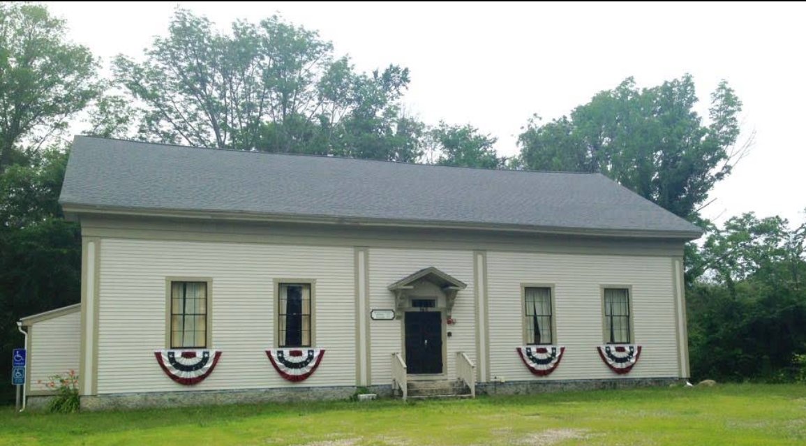 The Hopkinton Historical Society building, a white 19th-century meeting house decorated with patriotic bunting